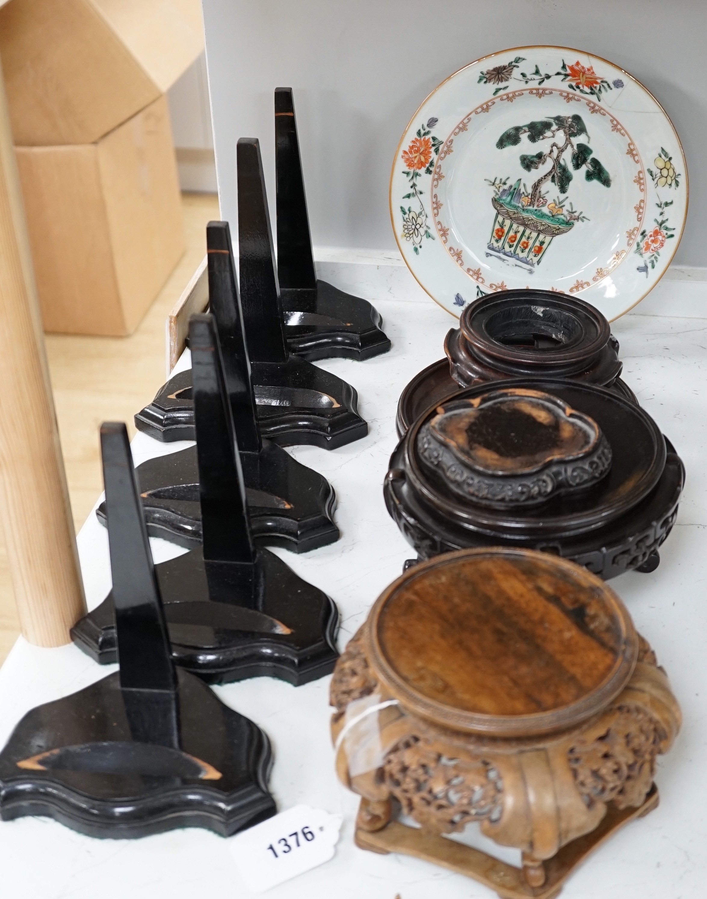 An 18th century Chinese export famille verte plate, Kangxi period Japanese carved wood stand and other various Chinese wood stands